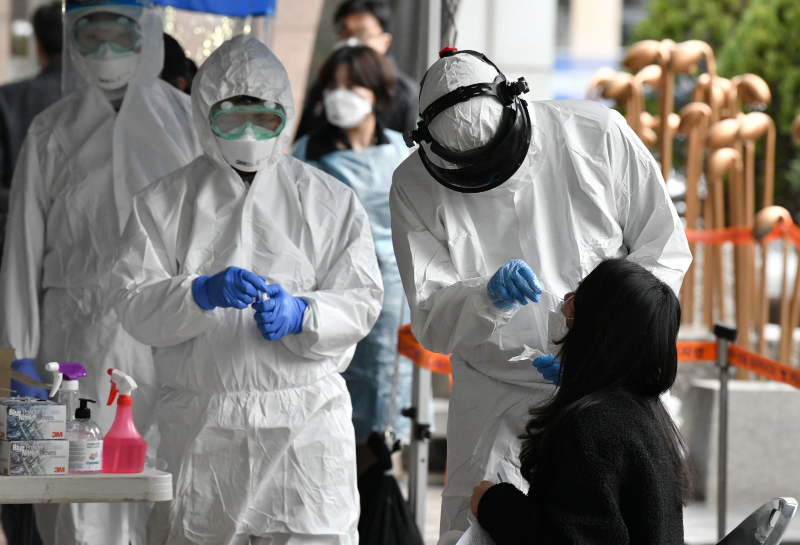 Nhân viên y tế Hàn Quốc lấy mẫu bệnh phẩm của các nhân viên bị nghi nhiễm Covid-19 tại một tòa nhà ở Seoul, nơi phát hiện 46 ca dương tính với virus SARS-CoV-2, ngày 10-3-2020. Ảnh: AFP/TTXVN