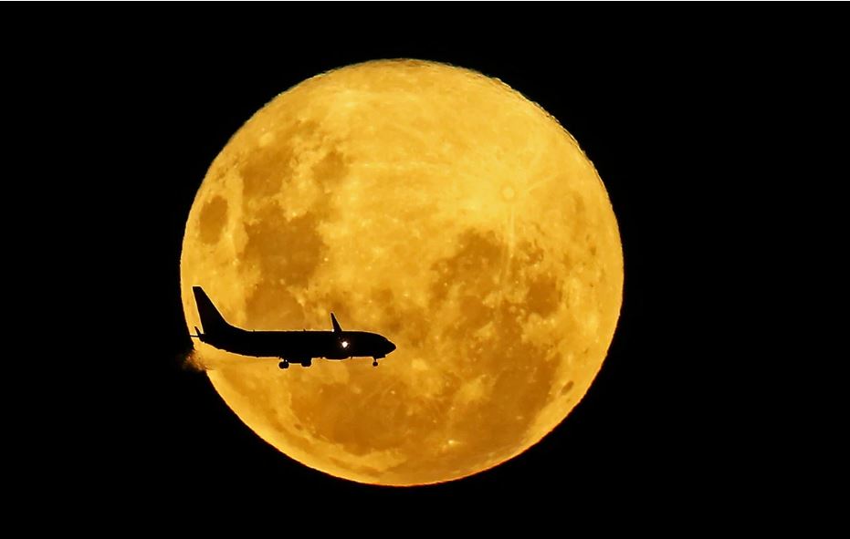 Một chiếc máy bay bay ngang qua Siêu Trăng Giun tại Curitiba, Brazil. Ảnh: AFP