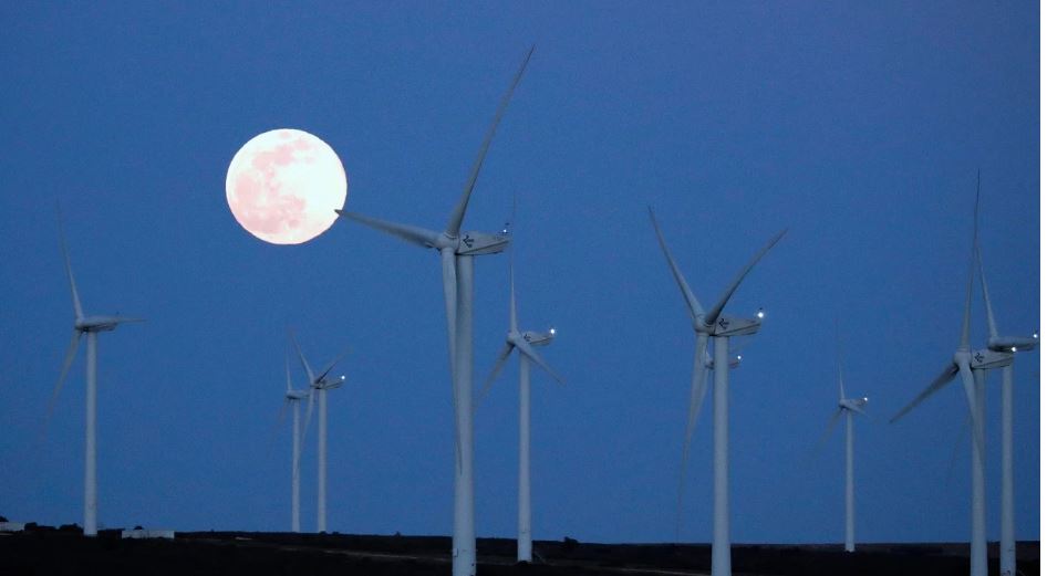 Siêu Trăng ngày 9-3 mọc phía trên một trang trại điện gió tại Villeveyrac, Pháp. Ảnh: EPA