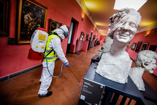 Phun thuốc khử trùng trong một bảo tàng ở Naples, thành phố lớn thứ 3 của Ý. 			      							         Ảnh: AP