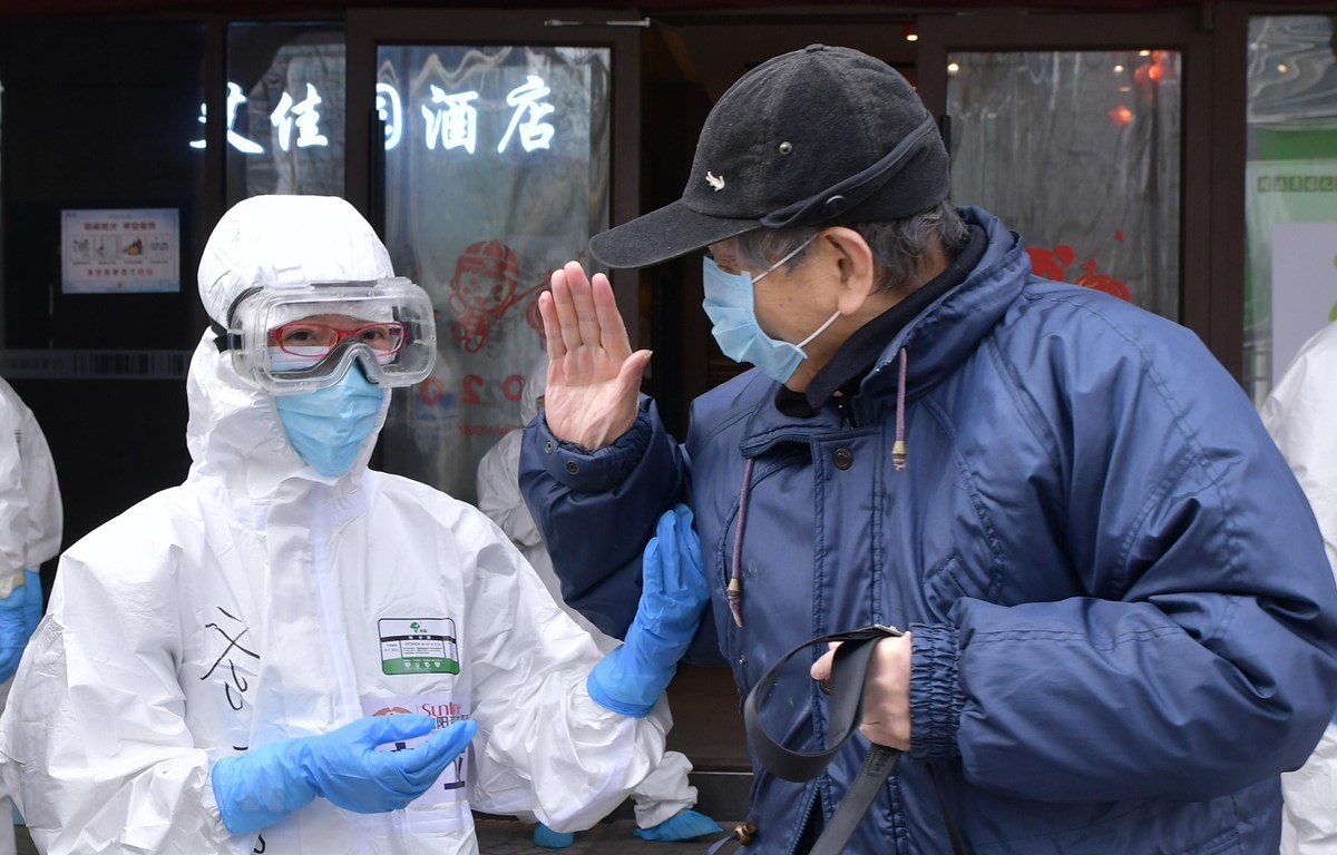 Bệnh nhân nhiễm Covid-19 tạm biệt bác sĩ sau khi được chữa khỏi tại bệnh viện ở Vũ Hán, tỉnh Hồ Bắc, Trung Quốc, ngày 10-3-2020. (Ảnh: THX/TTXVN)
