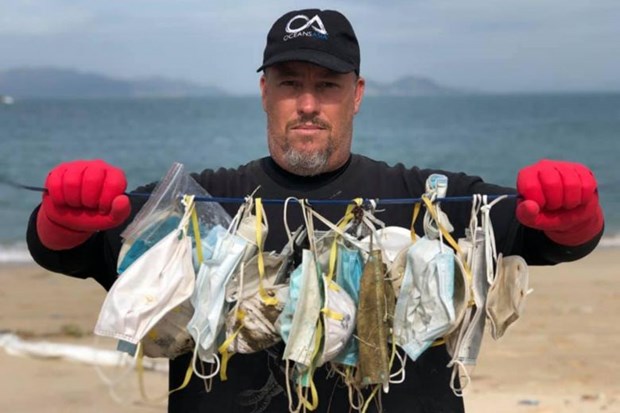 Ông Gary Stokes, người sáng lập nhóm môi trường OceansAsia, với những chiếc khẩu trang bị thải bỏ mà nhóm của ông tìm thấy trên bãi biển ở quần đảo Soko, Hong Kong. (Nguồn: straitstimes.com)