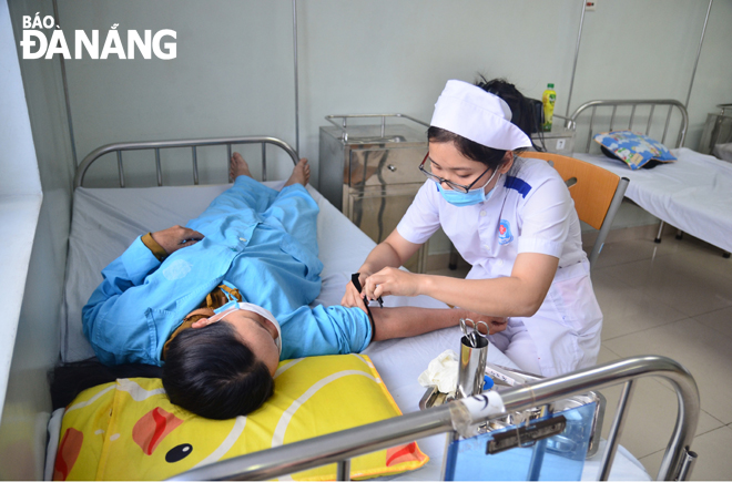 Cán bộ y tế khoa Ung bướu tổng hợp, Bệnh viện Ung bướu Đà Nẵng chăm sóc cho bệnh nhân. 