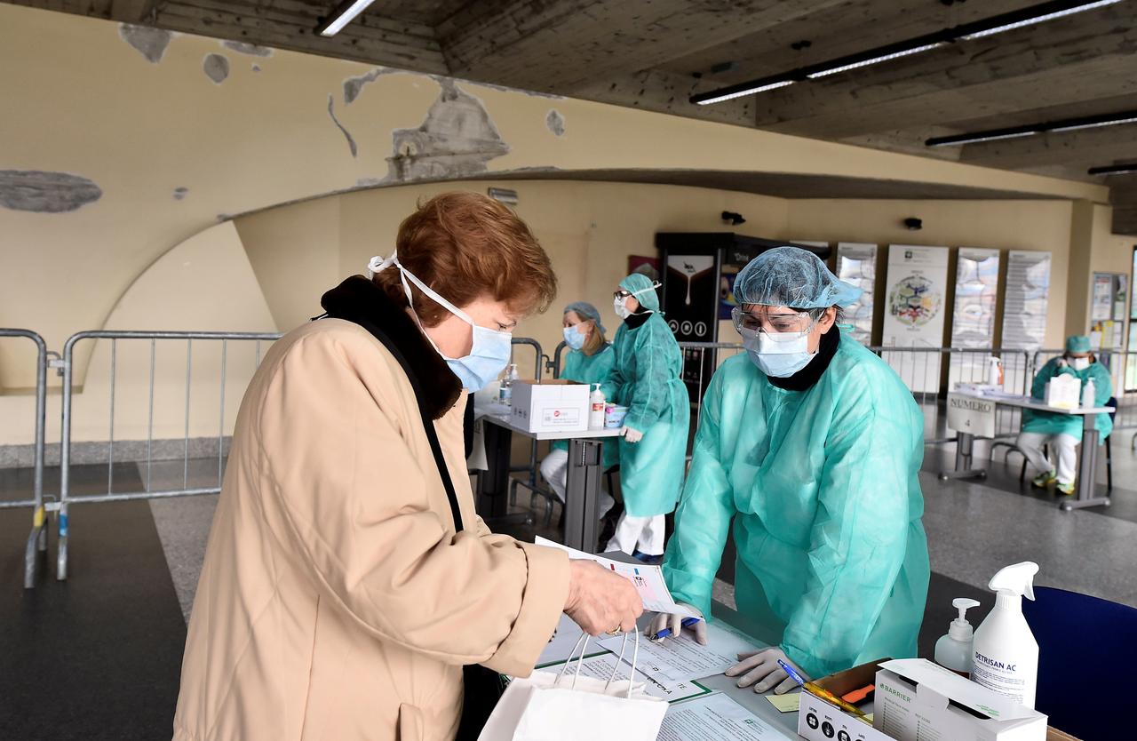 Nhân viên y tế kiểm tra thông tin bệnh nhân tại lối vào bệnh viện Spedali Civili ở Brescia, Italy, ngày 3/3. Ảnh: Reuters