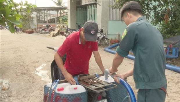 Người dân tới điểm tập kết lấy nước ngọt về phục vụ sản xuất. (Ảnh: Nam Thái/TTXVN)