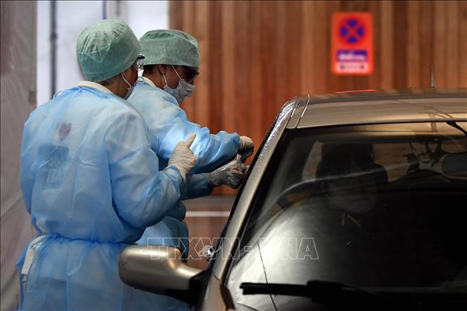  Nhân viên y tế lấy mẫu bệnh phẩm của một lái xe để xét nghiệm COVID-19 tại Liege, Bỉ ngày 10/3. Ảnh: AFP/TTXVN