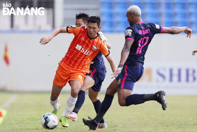 Với “cú đúp” vào lưới SHB Đà Nẵng (áo cam), Pedro Paolo (áo xanh, bìa phải) đã giúp Sài Gòn FC giành trọn 3 điểm.                              Ảnh: ANH VŨ