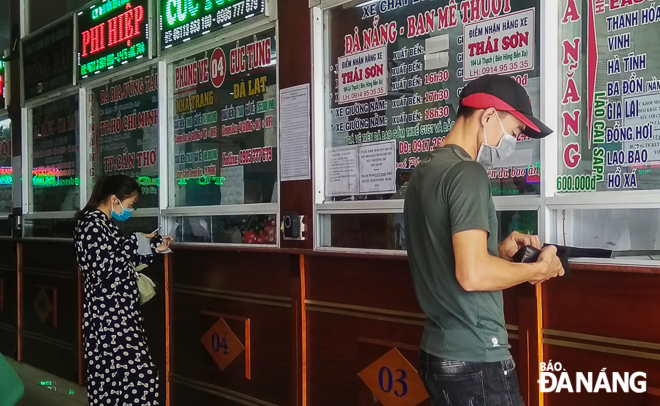 Hành khách đeo khẩu trang khi mua vé ở Bến xe Trung tâm Đà Nẵng. Ảnh: XUÂN SƠN
