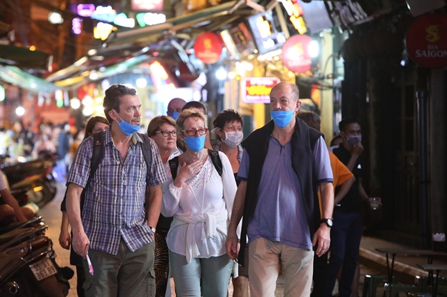 Foreign tourists wear face masks to stop the spread of COVID-19. Viet Nam requires all Vietnamese citizens and foreign people in Viet Nam to wear face masks in public places as from today. 