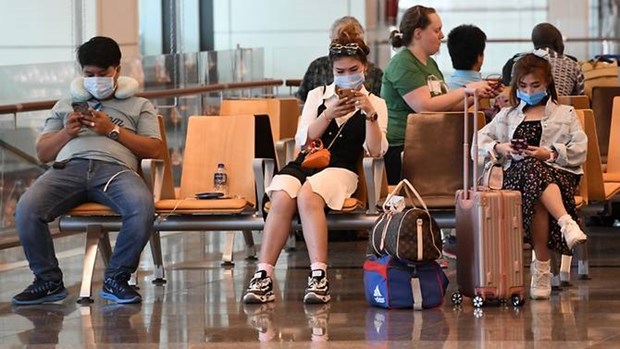 Travellers, wearing protective facemasks amid fears about the spread of the SARS-CoV-2, wait in the departure hall of Changi International Airport in Singapore on Feb 27, 2020. (Photo: AFP)