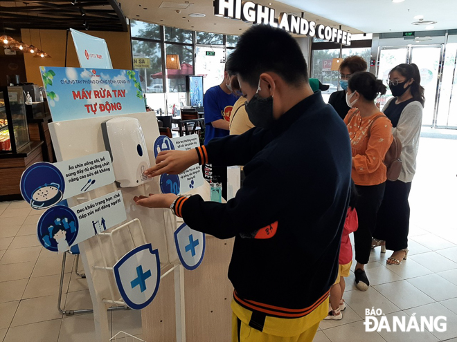 Shoppers cleaning their hands with hand sanitiser before entering the Lotte Mart