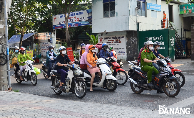 Local residents are seen wearing face masks travelling by motorbikes