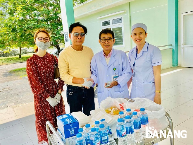 Mr Pham Thanh (2nd left) giving free face masks, food and water bottles, plus cash donations, to the charity kitchen of the Da Nang Hospital for Lung Diseases in February