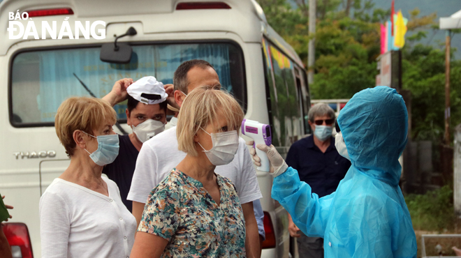 A healthcare worker from the Lien Chieu District Medical Centre checking the temperature of all arrivals to the city at a checkpoint at the southern end of the Hai Van Tunnel