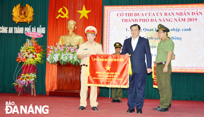 Chủ tịch UBND thành phố Huỳnh Đức Thơ (thứ 2, bên phải sang) trao Cờ thi đua của UBND thành phố năm 2019 cho Phòng CSGT Công an thành phố. Ảnh: NGỌC PHÚ
