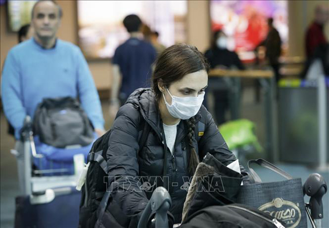 Hành khách đeo khẩu trang phòng lây nhiễm Covid-19 tại sân bay quốc tế Vancouver ở Richmond, Canada ngày 16-3. Ảnh: THX/TTXVN
