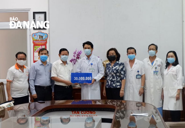 Head of the municipal Party Committee’s Department of Publicity and Training Tran Dinh Hong (1st left) and Chairman of the Da Nang Journalists' Association Nguyen Duc Nam (2nd left) giving cash donations of 30 million VND to the Da Nang General Hospital 