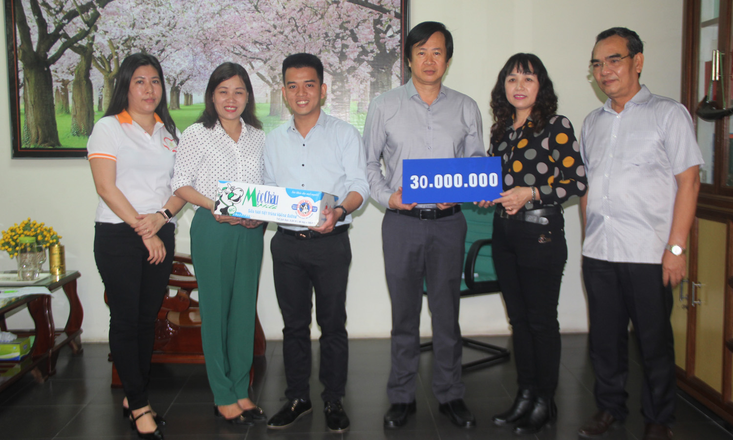 Representatives from the municipal Journalists' Association presenting 30 million VND in cash and 5 cartons of milks to the Centre for Disease Control