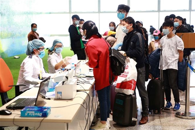 Passengers line up to wait to complete compulsory health declaration procedures  at Noi Bai International Airport