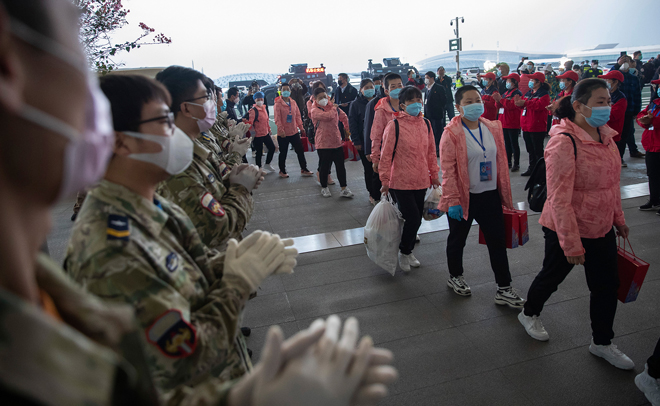Các nhân viên y tế đến sân bay quốc tế Thiên Hà ở Vũ Hán chuẩn bị rời thành phố này sau khi hoàn thành nhiệm vụ. 						                    Ảnh: AP