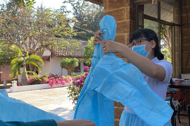 Các cán bộ y tế tập huấn cách mặc áo bảo hộ cho nhân viên phục vụ trong resort Phương Nam.