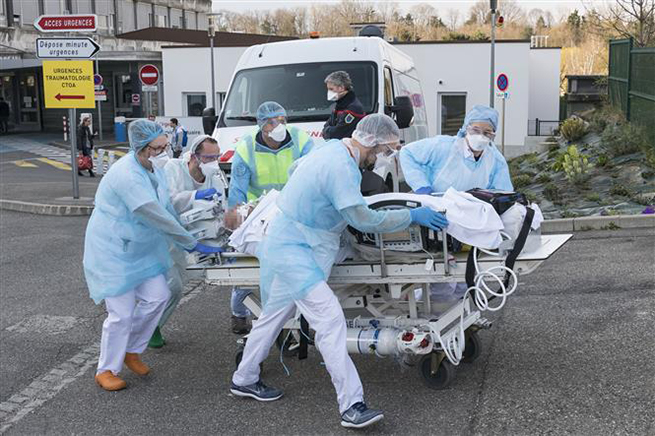 Nhân viên y tế chuyển bệnh nhân khỏi bệnh viện Emile Muller ở Mulhouse, miền Đông Pháp trong bối cảnh dịch Covid-19 bùng phát, ngày 17-3-2020. Ảnh: AFP/TTXVN
