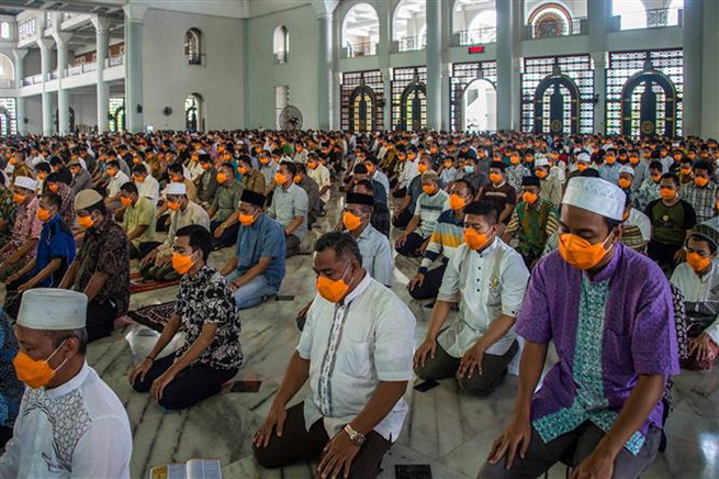 Người dân đeo khẩu trang phòng lây nhiễm Covid-19 trong khi cầu nguyện tại một nhà thờ Hồi giáo ở Surabaya, Đông Java, Indonesia ngày 20-3-2020. Ảnh: AFP/TTXVN