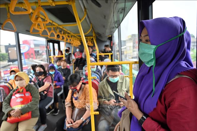 Hành khách đeo khẩu trang trên xe buýt tại Jakarta, Indonesia, ngày 18-3. Ảnh: AFP/TTXVN