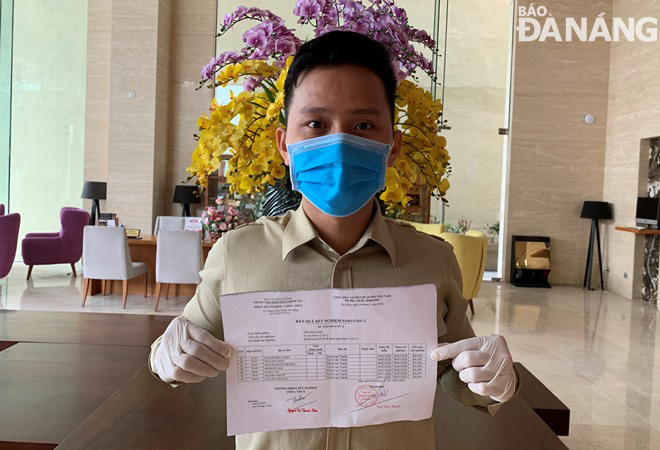 A hotel employee happy with his negative test result for SARS-CoV-2