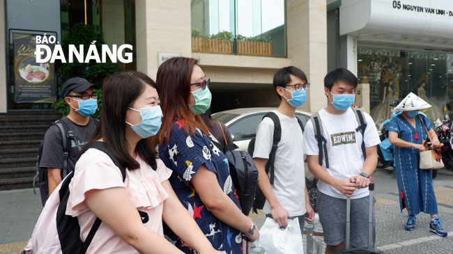 Tourists waiting for transportation vehicles in front of the Vanda Hotel to go to Da Nang International Airport 