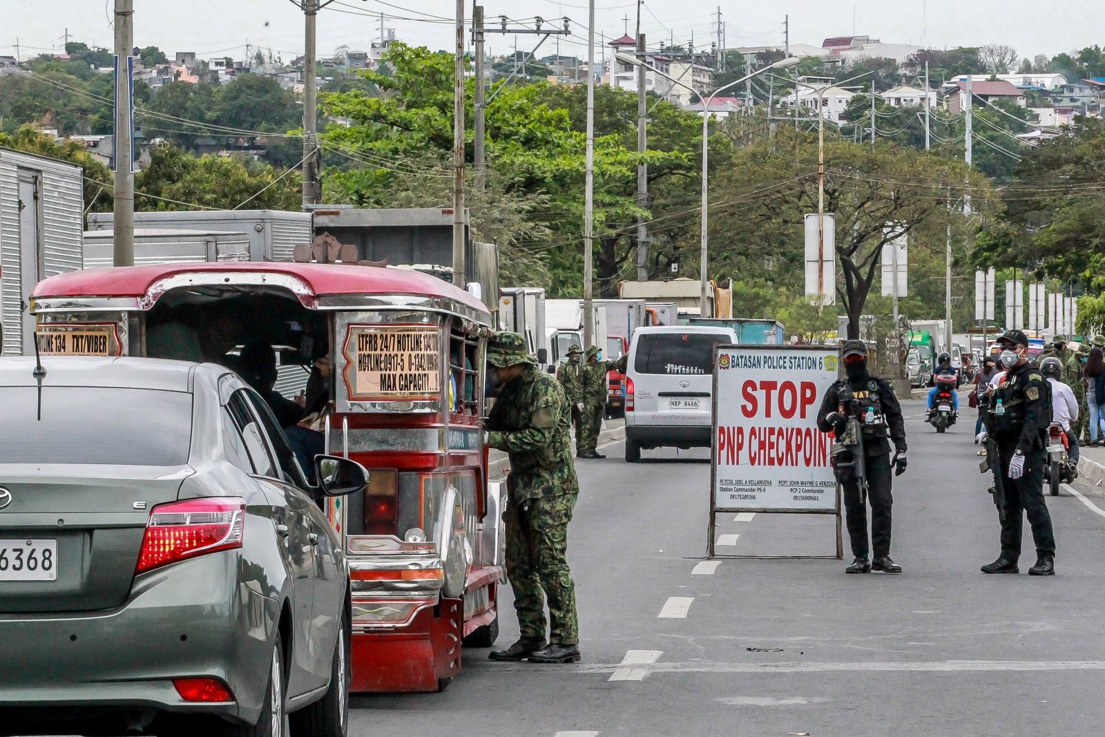 Cảnh sát kiểm tra thân nhiệt của người dân tại một điểm kiểm soát ở Quezon, Philippines ngày 16/3/2020, nhằm ngăn chặn sự lây lan của COVID-19. Ảnh: THX/ TTXVN