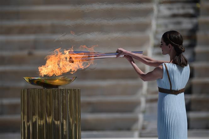 Ngày 19/3/2020, Hy Lạp đã trao ngọn đuốc Thế vận hội (Olympic) mùa Hè 2020 cho Nhật Bản trong buổi lễ được tối giản hết sức do lo ngại nguy cơ lây lan dịch bệnh viêm đường hô hấp cấp COVID-19. Trong ảnh: Diễn viên Hy Lạp Xanthi Georgiou trong trang phục nữ tư tế tối cao thắp ngọn đuốc Olympic trong lễ trao đuốc cho Nhật Bản tại Athens, Hy Lạp, ngày 19/3/2020. Ảnh: THX/ TTXVN