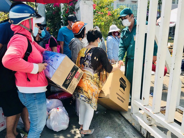Lượng hàng tiếp tế trong buổi sáng 22/3 khá đông khiến cổng khu cách ly tại KTX Đại học Quốc gia TP Hồ Chí Minh luôn trong tình trạng ùn ứ. (ảnh: TTXVN)