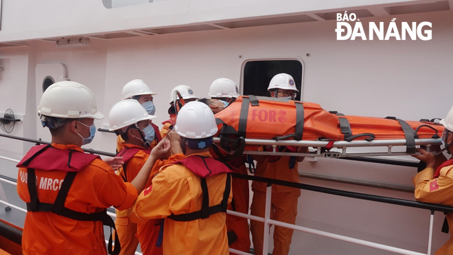 Rescuers transferring the victim from fishing boat QNg 98536 TS to their rescue ship