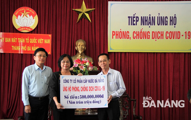 Chairwoman of the municipal Fatherland Front Committee Dang Thi Kim Lien (centre) receiving cash donations from the Da Nang Water Supply JSC 