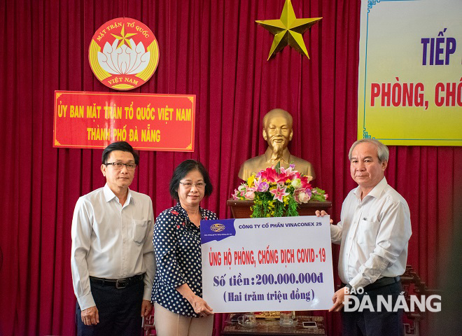 Chairwoman of the municipal Fatherland Front Committee Dang Thi Kim Lien (centre) receiving donations from Vinaconex 25 Company representative