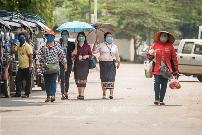 Người dân đeo khẩu trang tại thủ đô Viêng Chăn, Lào ngày 23-3. Ảnh: THX/TTXVN