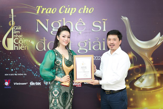Ông Lê Xuân Thành (Tổng Biên tập Báo Thể thao và Văn hóa) trao cup cống hiến cho ca sỹ Tân Nhàn. (Ảnh: BTC)