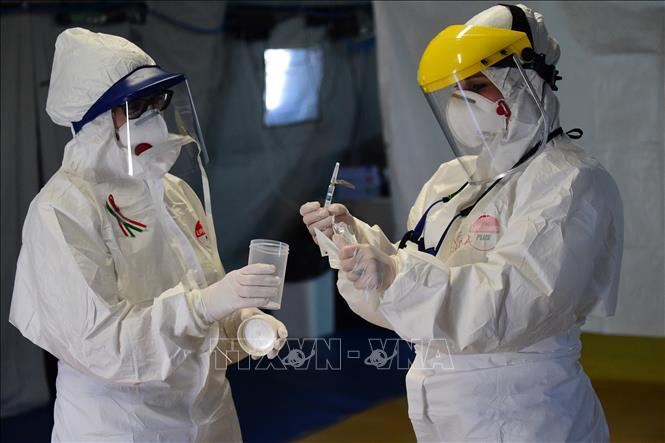 Nhân viên y tế kiểm tra thiết bị xét nghiệm phát hiện virus SARS-CoV-2 tại Bologna, Italy ngày 23-3. Ảnh: THX/TTXVN