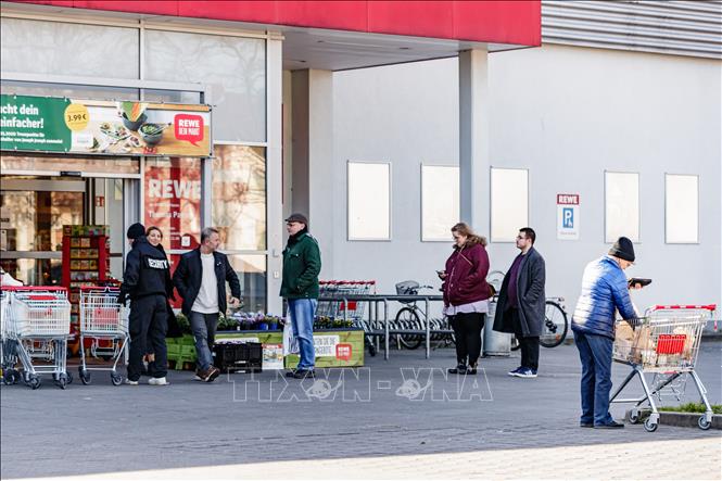 Người dân xếp hàng bên ngoài một siêu thị ở Berlin, Đức ngày 23-2. Ảnh: THX/TTXVN