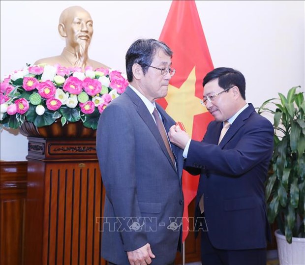 Deputy Prime Minister and Foreign Minister Pham Binh Minh (R) presents Friendship Order to Japanese outgoing ambassador Umeda Kunio (Photo: VNA)