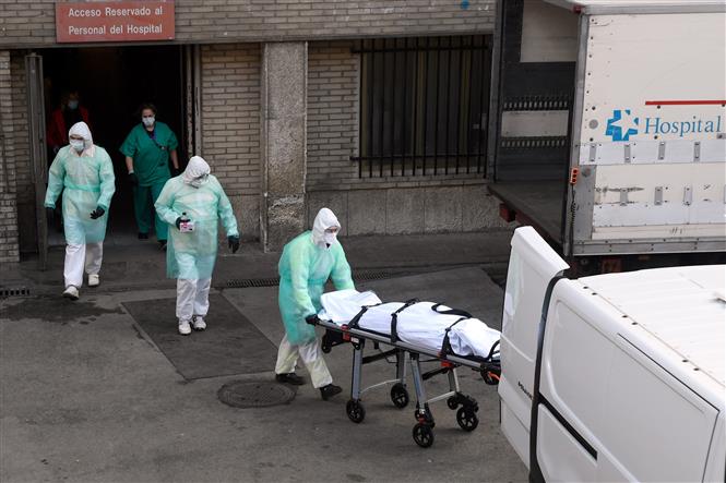 Nhân viên y tế chuyển thi thể bệnh nhân nhiễm COVID-19 tại bệnh viện Gregorio Maranon ở Madrid, Tây Ban Nha. Ảnh: AFP/TTXVN