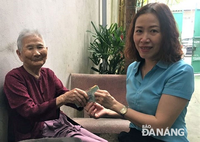 Ms Nguyen Thi Thanh Huong, Chairwoman of the Thanh Binh Ward Fatherland Front Committee in Hai Chau District, (right) receiving donations from heroic Vietnamese mother Le Thi Chi 
