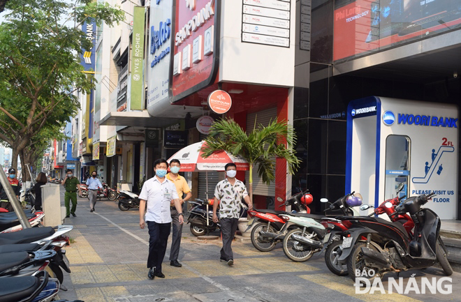 UBND phường Nam Dương kiểm tra tình hình hoạt động của các cơ sở kinh doanh dịch vụ trên đường Nguyễn Văn Linh. Ảnh: HOÀNG HIỆP