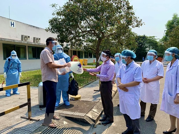 Lãnh đạo Sở Du lịch tỉnh Thừa Thiên-Huế trao tặng món quà nón lá đặc trưng địa phương cho bệnh nhân. (Ảnh: Mai Trang/TTXVN)