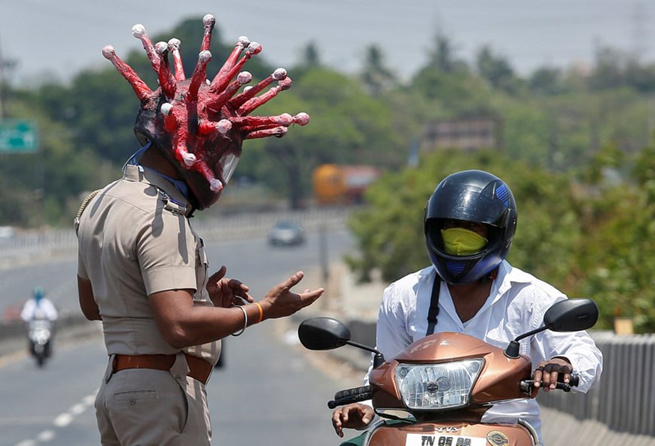 •       Cảnh sát Ấn Độ đeo mũ mô phỏng virus corona để nhắc nhở người dân ở nhà. (Ảnh: Reuters)