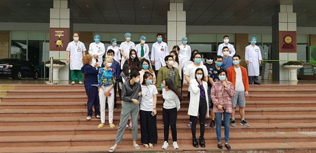 Patients have a photo taken with doctors and medical workers at the National Hospital of Tropical Diseases (NHTD) on March 30. (Photo courtesy of NHTD)