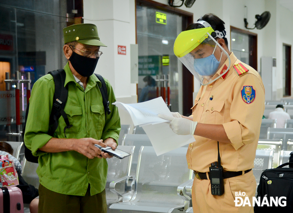 A police officer helping a male passenger to fill in a health form