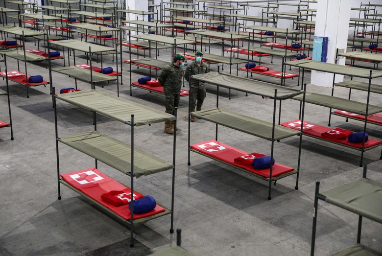 Lục quân Tây Ban Nha xếp giường trong trung tâm hỗ trợ người vô gia cư tại Barcelona. Ảnh: Reuters