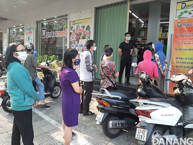 Người dân đứng xếp hàng mua hàng hóa trước cổng vào siêu thị Danamark (đường Phan Đình Phùng) vào chiều 31-3. Ảnh: KHÁNH HÒA